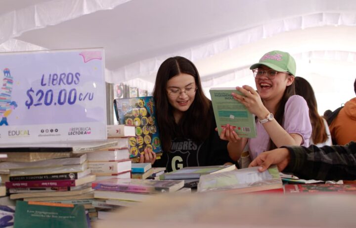 Jóvenes revisan libros durante el 22º Gran Remate de Libros, Discos y Películas en el Monumento a la Revolución
